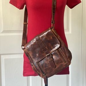 Brown Leather Messenger Bag with Adjustable Strap and Buckle Closure.